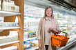 © Liubomir - Portrait of senior gray-haired woman in supermarket, looking at camera and smiling and shopping cart