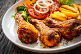 Fototapeta Kawa jest smaczna - Barbecue chicken drumsticks with chips and greens on wooden table
