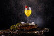 canvas print picture - Weincocktail im Glas auf Schieferstein mit Moss und Wasserfall fotografiert