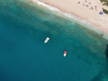Aerial Top View Of Sea Waves And White Boats On The Beach With Turquoise Sea Water. Sea Waves On The Wild Rocky Coast. Seascape. Travel Concept. Aegean Sea, Turkey. Postcard View. Drone Shot