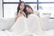 © Nutlegal - Portrait two cheerful young asian women sit together and looking at camera LGBT couple lesbian couple or friendship concept Happy young asian homosexual girls Lesbian women get romantic copy space