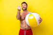 Middle age caucasian man holding beach ball isolated on yellow background making money gesture