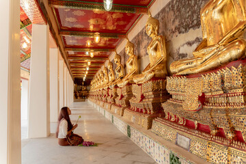 beauty asia woman praying in an ancient thailand temple , at Wat Suthat Thepwararam