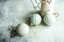 Overhead View Of Three Green Ceramic Christmas Baubles Next To A Vase