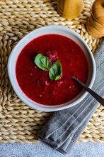 Overhead View Of A Bowl Of Beetroot Soup With Basil Garnish