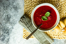 Overhead View Of A Bowl Of Beetroot Soup With Basil Garnish