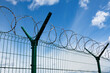 Barbed wire fence with the sky in the background.
