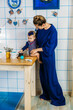 © irissca - The first fruits and berries for babies. Mother and baby toddler daughter eating blackberries in home kitchen.