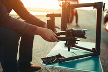 Man Sitting Outdoors Setting Up Stabilizer And Gimbal Equipment To Shoot A Video