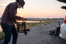 Man Using A Gimbal And Stabilizer To Shoot A Video At Sunset