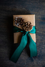 Overhead View Of A Gift Box With A Tied Bow And Pinecone Decorations