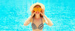 Summer sunny portrait smiling woman holds in hands oranges and hides his eyes on blue water pool background
