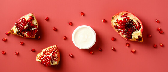 Wall Mural - hand cream with extract of pomegranate on a red background. vitamin c natural cosmetic product