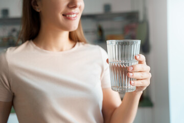 Young female hand holds glass of clear water cropped shot