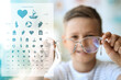 Collage with eye test chart and little boy holding glasses