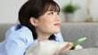 © japolia - スマートフォンを見ながら考え事をする若い女性