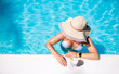 © Kaspars Grinvalds - Woman with summer hat relaxing in swimming pool, view from above