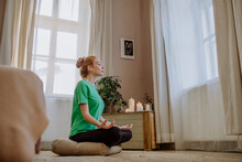 Woman With Eyes Closed Practicing Breathing Exercise At Home
