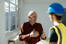 Architect Discussing With Construction Worker At Office
