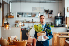 Freelancer With Plant Standing At Cafe