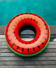 Watermelon Shaped Inflatable Ring Lying On Edge Of Swimming Pool