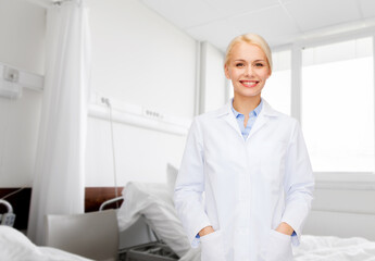 Poster - medicine, healthcare and people concept - smiling female doctor over hospital ward background