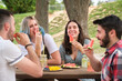 © Ladanifer - Group of happy friends having fun, drinking and eating watermelon in a park. Picnic on a sunny summer day.