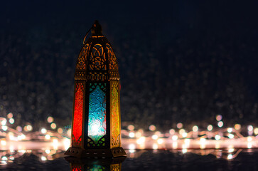 Wall Mural - Lantern with lights decorating for Islamic new year put at window with rain drop at background.