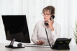 © JeanPaul - Front view of a businesswoman with eyeglass using computer and talking on the phone