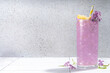 Lilac drink. Alternative organic natural cocktail or mocktail, infused drink from lilac flowers. Lilac lemonade with ice in a tall long glass.
