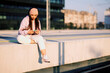 © chika_milan - A teenage girl sitting on railroad station and listening music on the phone.