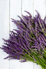 Wall Mural - purple lavender flowers heap on faded white wooden table background, directly above