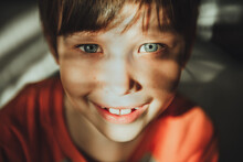 Little Child Boy Smiling With Sunny Rays On Face. Cute Child With Blue Eyes Smiling. Vintage Lens Kids Home Portrait In Daylight. Growing Up Psychology Personal Development