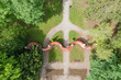 Park dworski w mieście Iłowa w zachodniej Polsce. Widać parkową fontannę, alejkę i mur ceglany zwany bramą księżycową. Widok z drona.