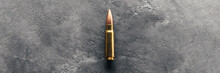 Bullet On Gray Background Banner With Copy Space. Cartridge 7.62 Caliber For Kalashnikov Assault Rifle. Panoramic Web Header. Wide Screen Wallpaper