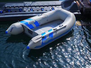 An inflatable gray-blue motor boat is moored in a sea bay with shining water