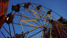 Pods Of Ferris Wheel Are Rotating Against Evening Clear Sky. Festival Atmosphere Video Footage. 