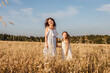© Татьяна Максимова - Young mother and daughter dance in field.