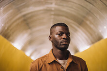 Portrait Of Young Man Standing In Subway Tunnel