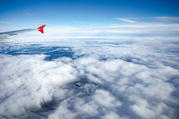 Wall Mural - aircraft wing above beautiful clouds and blue sky