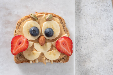 Sticker - Kids breakfast or lunch or snack toast with peanut butter spread, banana, strawberry and blueberry shaped as cute owl.