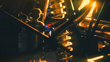 Close-up Details Of Car Engine On Background Of Bright Light. Stock Footage. Yellow Light Illuminates Dark Shapes Of Parts With Springs And Cylinders For Car
