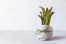 Bundle Of Asparagus In A Pot On The Grey Background