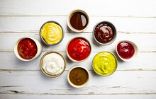 Set Of Different Bowls Of Various Dip Sauces On White Background, Top View