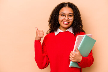 Young student African American woman isolated on beige background smiling and raising thumb up