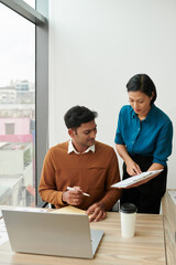 Wall Mural - young businesswoman asking colleague to sign documant on clipboard