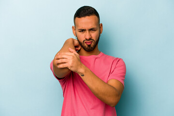 Wall Mural - Young hispanic man isolated on blue background having a neck pain due to stress, massaging and touching it with hand.