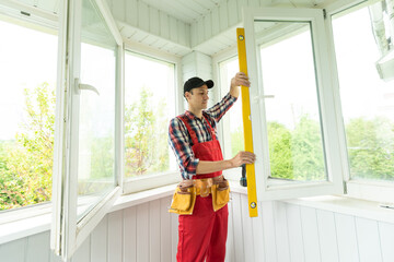 Man measuring window prior to installation of roller shutter outdoors.