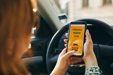 Woman Using Mobile Parking App On Smartphone. Driver Using Smartphone To Pay For Parking. Car Park Application On Mobile Phone. Paying For Parking Using Fast Payment Online