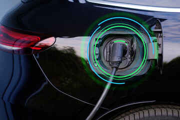 close-up of part of black car charging energy, replenish battery charging station, alternative energy development concept, electric vehicle production, global business, electric energy storage